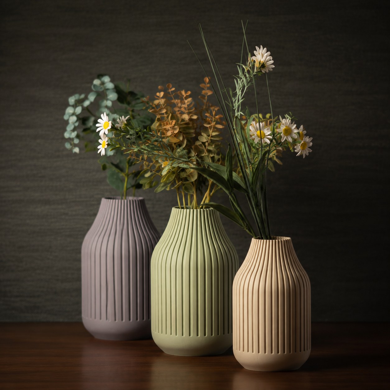 Three ribbed 3D printed vases in lilac, sage and sand holding dried flowers